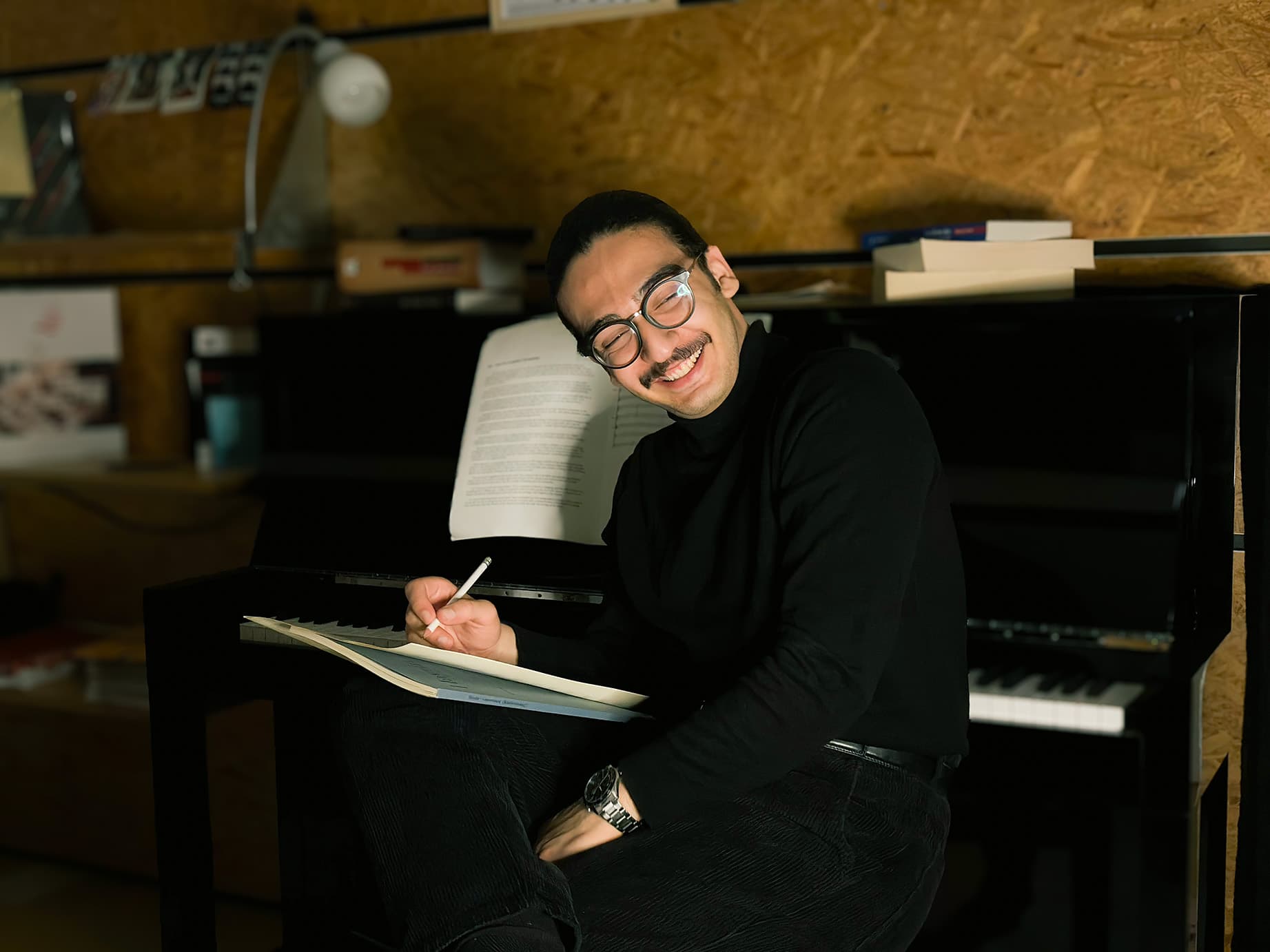 Parsa B. Sabet at the piano, writing a score